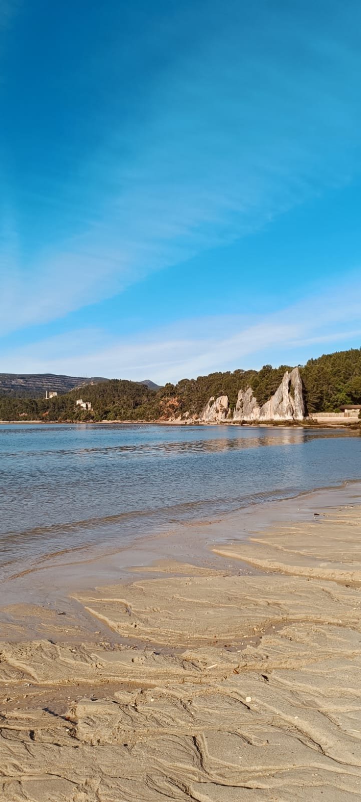 Praia junto a rochedo em forma de agulha